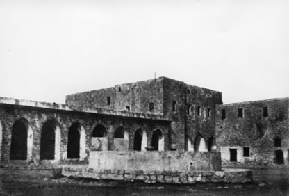 The barracks square of the prison. Bahá’u’lláh was first held in a room adjacent to the square and later moved to his cell on the second floor of the building in the center of the photo.