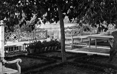 The flower pots on the ground mark the location of the bench where Bahá’u’lláh often sat when He visited the garden. The river can be seen in the background.